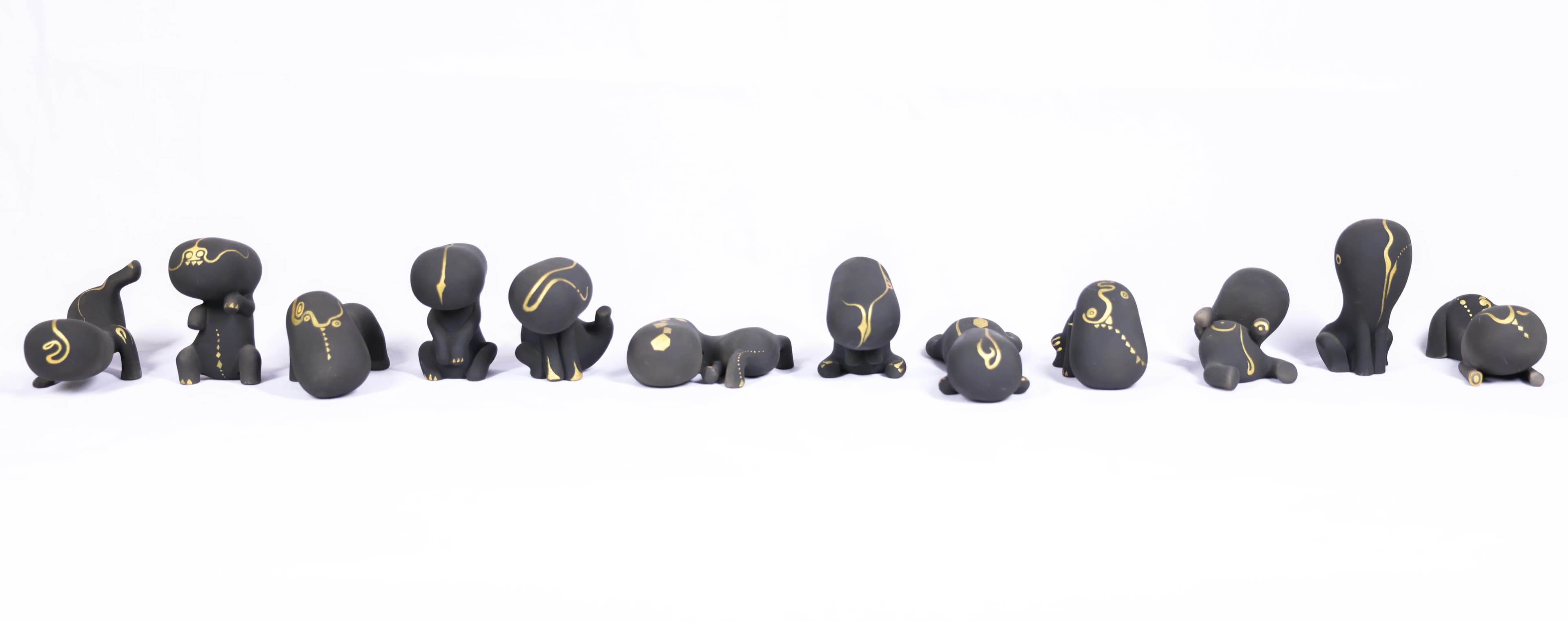 A group display of twelve Lucky Doll ceramic figures